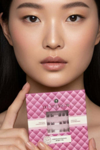 Femme asiatique au maquillage naturel tenant le boîtier Mi-Xtension X-Press Style Couture, bouquets de cils auto-adhésifs pour un regard sublimé sans colle