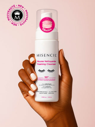 Mousse Nettoyante Misencil Vanille tenue en main, flacon blanc 100 ml sur fond rose, nettoyant yeux et visage 98 % naturel.
