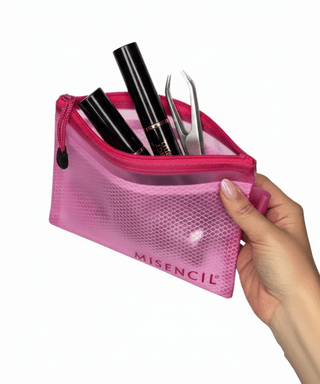 Trousse Misencil rose en mesh nylon tenue en main, contenant maquillage et pince pour extensions de cils