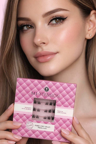 emme blonde au teint lumineux tenant le boîtier Mi-Xtension X-Press Style Couture, extensions de cils press-on effet couture, pose rapide et regard professionnel